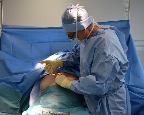 Person applying a cold gel pack to their knee joint